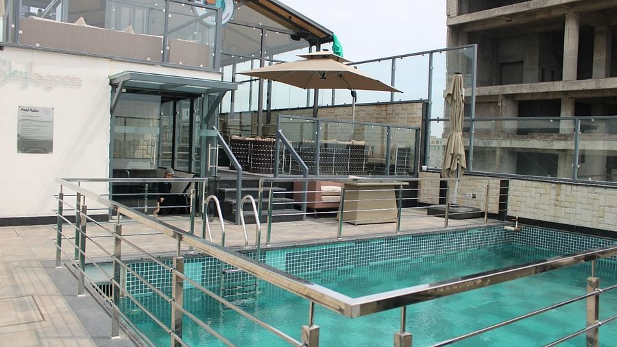 Rooftop swimming pool with a staircase at the back leading to the lounge area at BluSalzz Residence, Amritsar.
